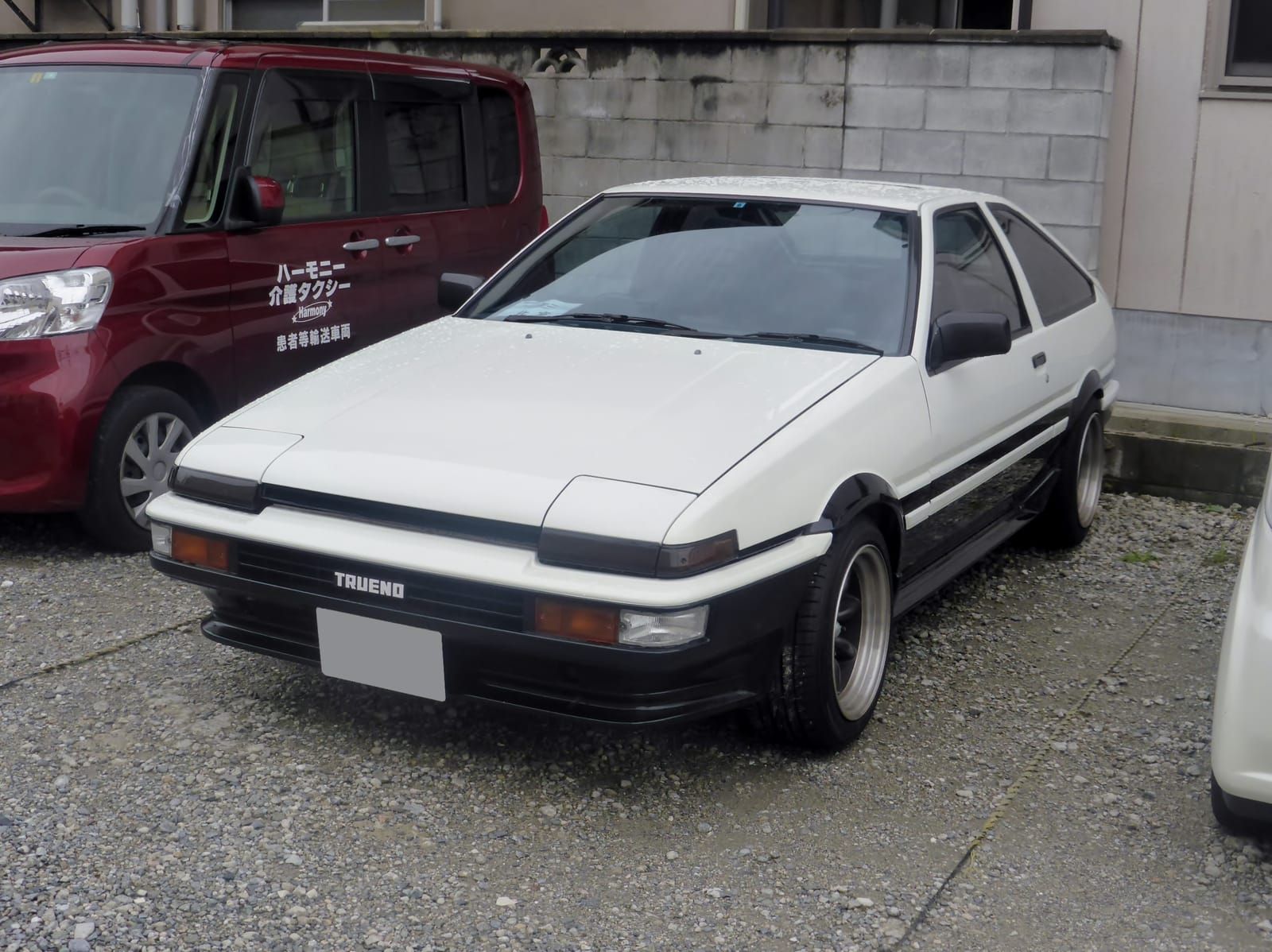 A white-and-black panda Toyota Sprinter Trueno AE86 parked in Japan