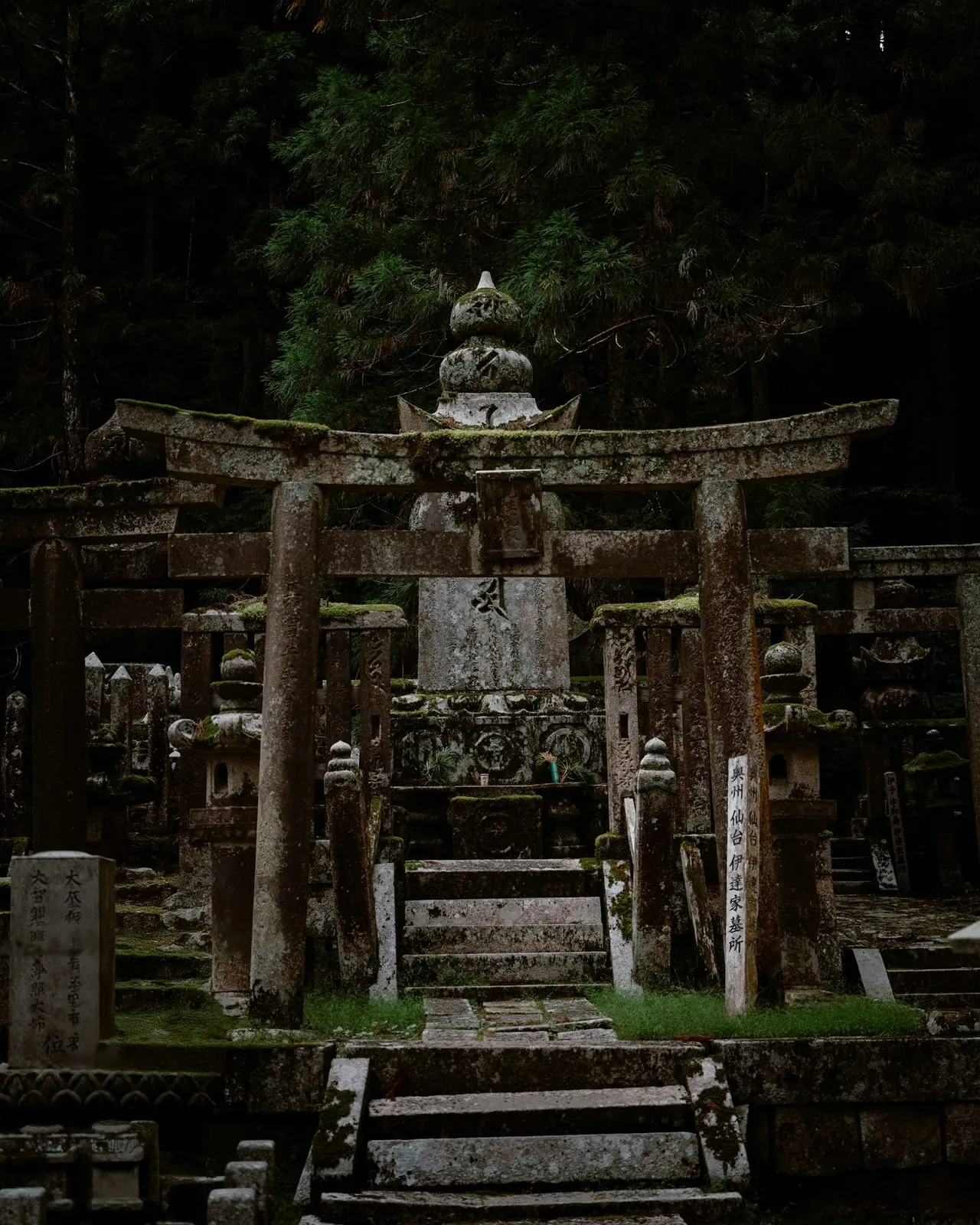A stone statue among moss-covered graves in the Okunoin cemetery, Koyasan
