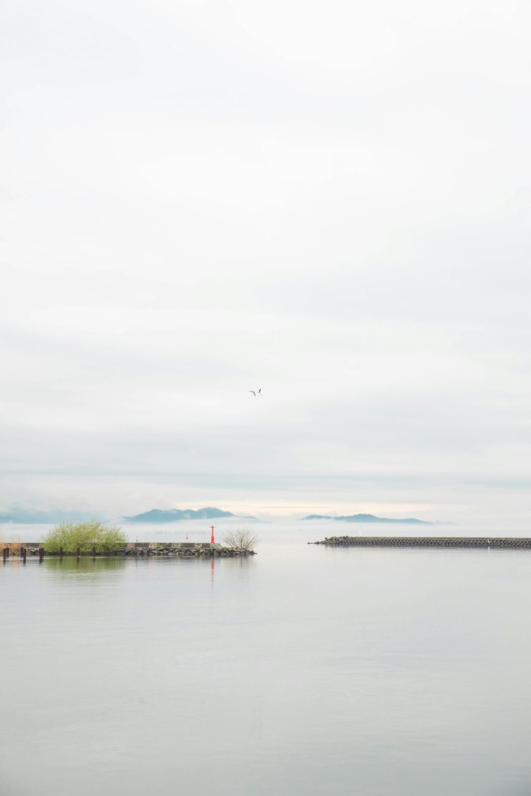 Calm water of Lake Biwa in Shiga with a small island on the horizon