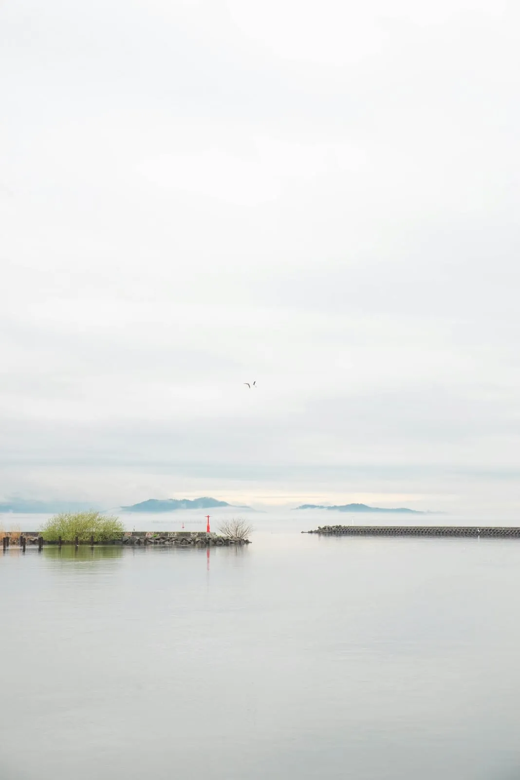Calm water of Lake Biwa in Shiga with a small island on the horizon