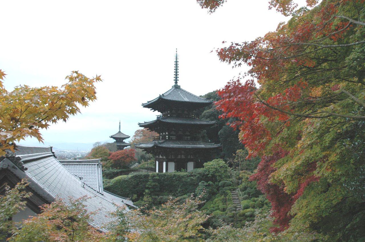 The twin Nara-period east and west pagodas of Taima-dera framed by autumn maples, Nara